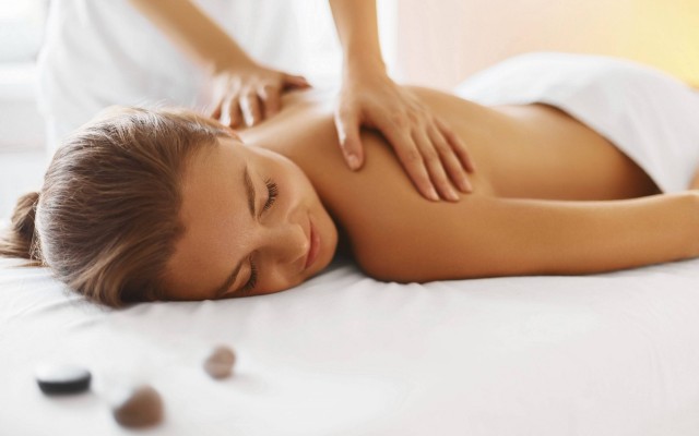 Spa woman. Female enjoying relaxing back massage in cosmetology spa centre. Body care, skin care, wellness, wellbeing, beauty treatment concept.
